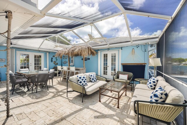 sunroom featuring lofted ceiling, ceiling fan, and french doors