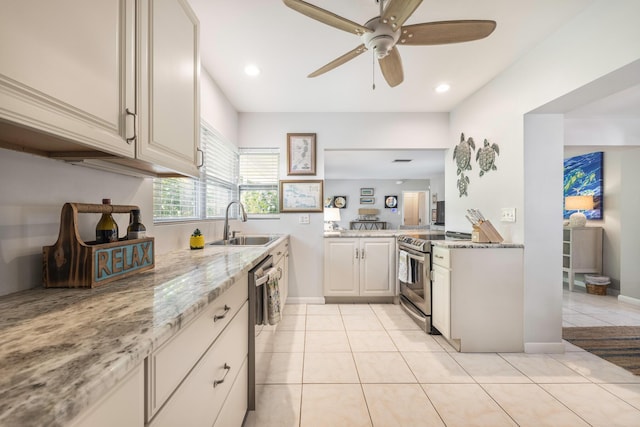 kitchen featuring sink, light tile patterned floors, ceiling fan, stainless steel appliances, and light stone countertops