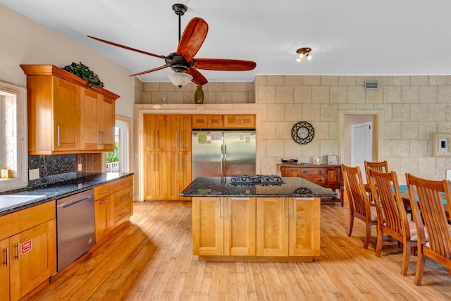 321 Calzada De Bougainville, Marathon, FL 33050 - kitchen with appliances with stainless steel finishes, ceiling fan, light wood-type flooring, a center island, and dark stone countertops