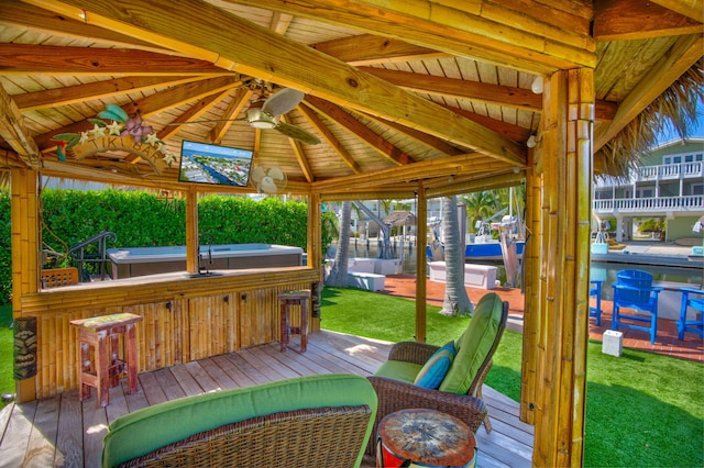 wooden deck with exterior bar and ceiling fan