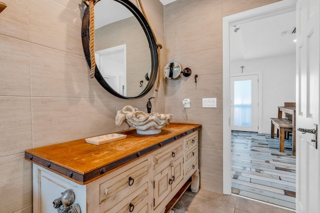 bathroom featuring vanity, tile patterned flooring, and tile walls