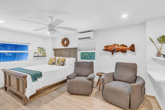 bedroom with a wall unit AC, light hardwood / wood-style floors, and ceiling fan