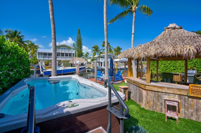 view of swimming pool with a water view, a bar, and a gazebo