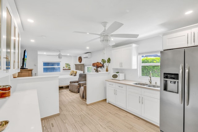 kitchen featuring sink, light hardwood / wood-style floors, stainless steel fridge with ice dispenser, and white cabinets