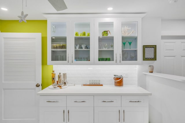 bar featuring backsplash and white cabinets