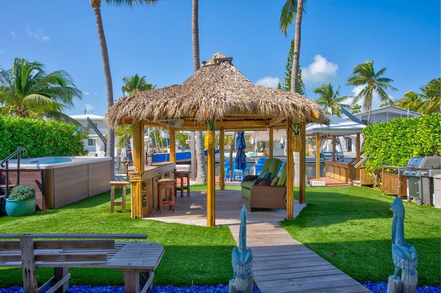 exterior space featuring a gazebo, a yard, a jacuzzi, and a deck