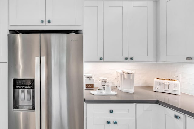 kitchen featuring tasteful backsplash, stainless steel fridge with ice dispenser, and white cabinets