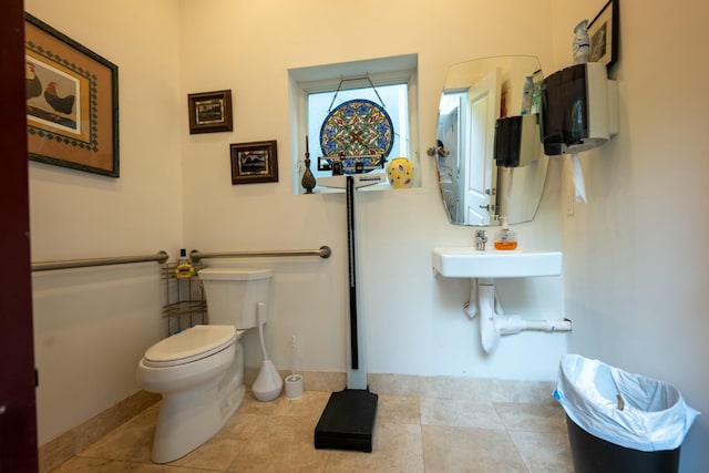 bathroom with tile patterned flooring, baseboards, and toilet