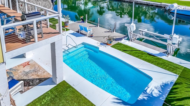 view of swimming pool with a water view and a dock