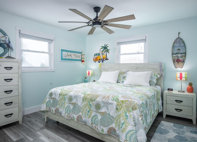 bedroom with multiple windows, wood-type flooring, and ceiling fan