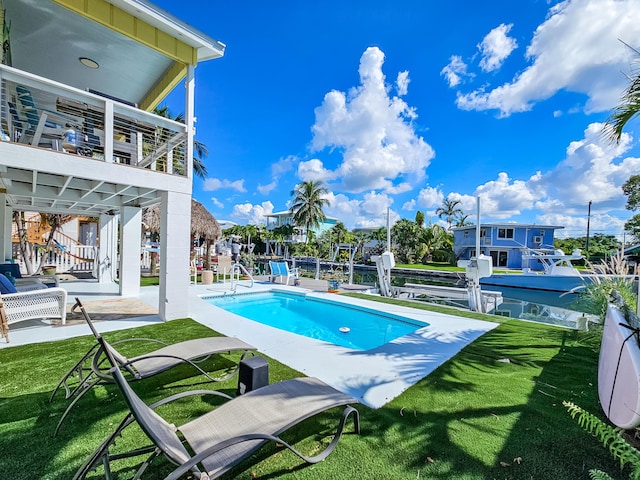 view of swimming pool with a yard and a patio area