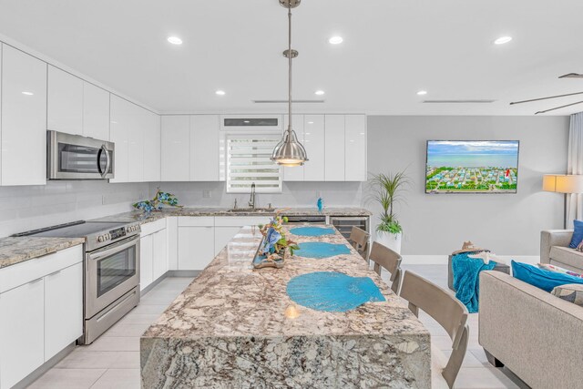94825 Overseas Hwy Unit 61, Key Largo, FL 33037 - kitchen featuring sink, stainless steel appliances, white cabinets, a kitchen island, and decorative light fixtures