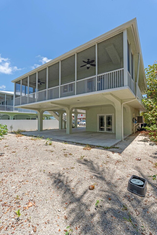 973 Gibraltar Rd, Key Largo, FL 33037 - back of house featuring a sunroom, a ceiling fan, a carport, and driveway