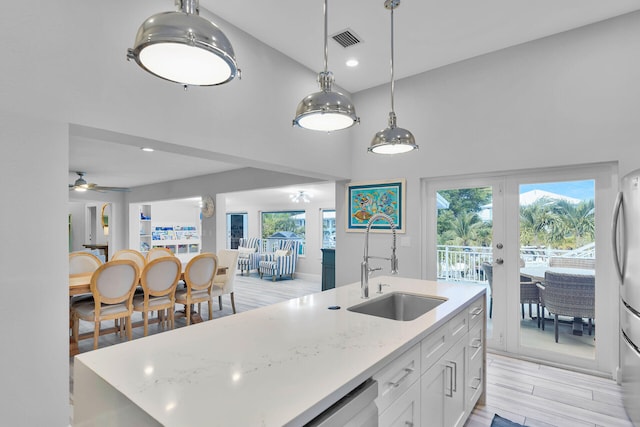 853 Ellen Dr, Key Largo, FL 33037 - kitchen featuring a sink, high vaulted ceiling, white cabinetry, ceiling fan, and a center island with sink