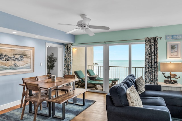 living room with a water view, ceiling fan, and light hardwood / wood-style flooring