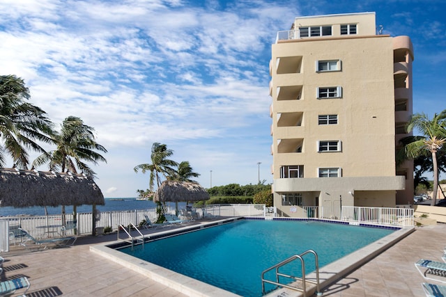 view of pool with a patio, a water view, and a gazebo