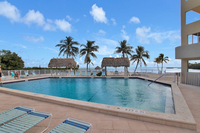 view of pool featuring a gazebo, a water view, and a patio