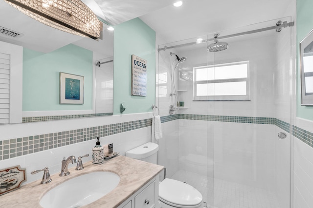 bathroom with vanity, toilet, an enclosed shower, and tile walls