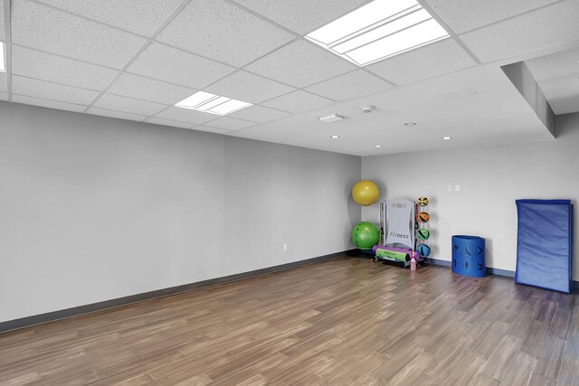 exercise area with a drop ceiling and wood-type flooring