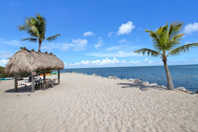 property view of water featuring a gazebo and a beach view