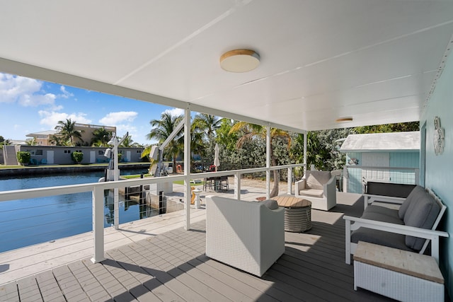 wooden terrace featuring a water view and outdoor lounge area