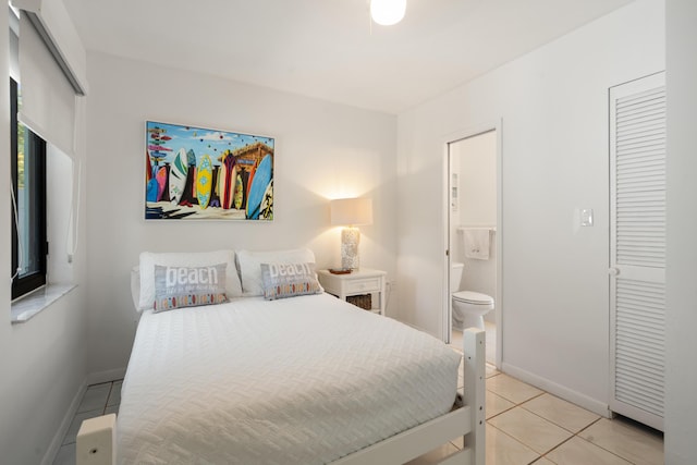 bedroom with ensuite bathroom and light tile patterned flooring