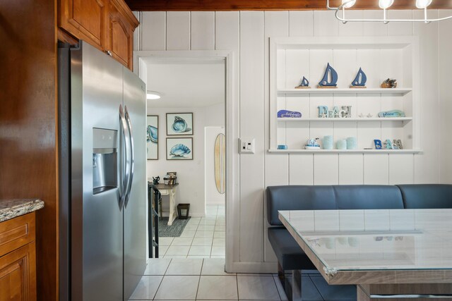 interior space featuring stainless steel refrigerator with ice dispenser, light tile patterned floors, and built in features