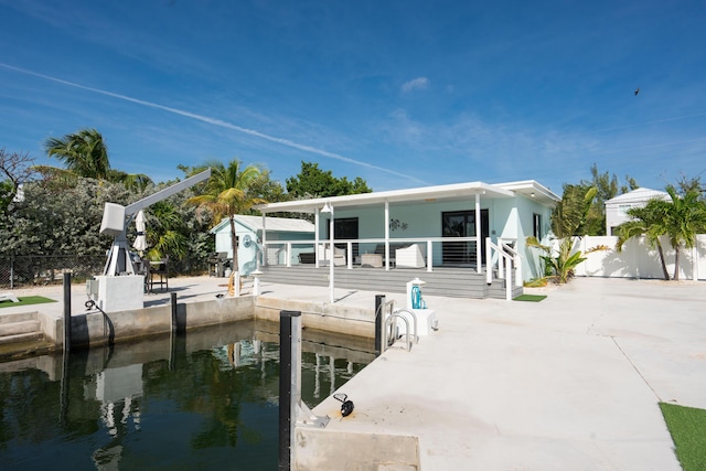 rear view of house featuring a patio area and a water view