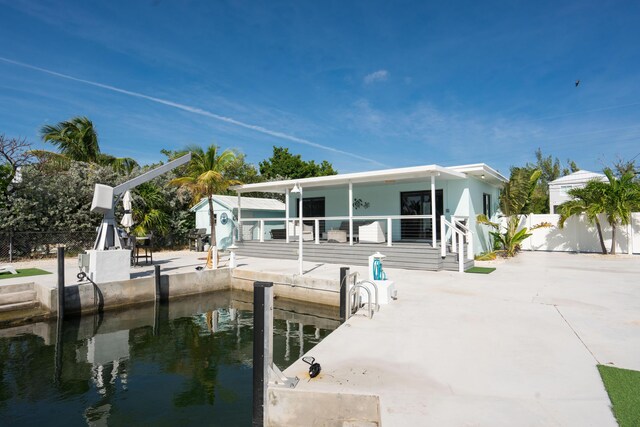 rear view of property featuring a water view and a patio area