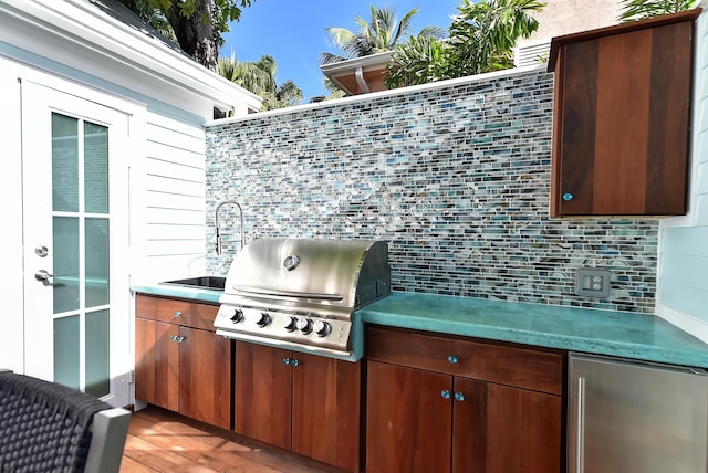 view of patio / terrace with a grill, sink, and an outdoor kitchen