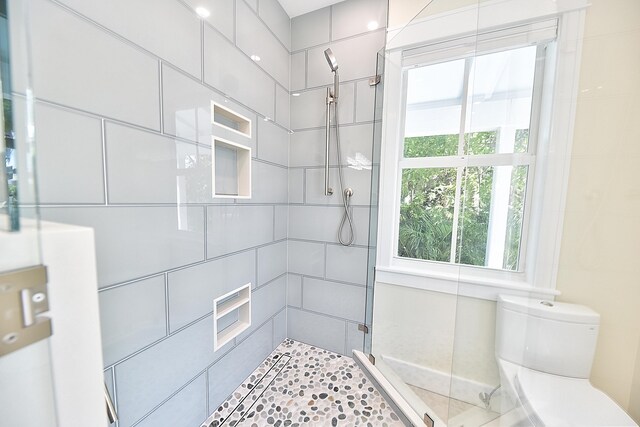 bathroom featuring toilet and tiled shower