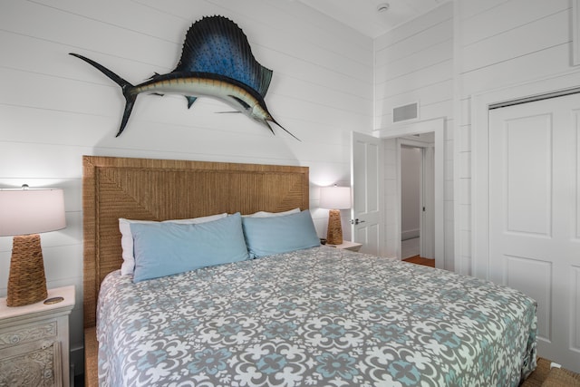 bedroom featuring a towering ceiling, visible vents, and wooden walls