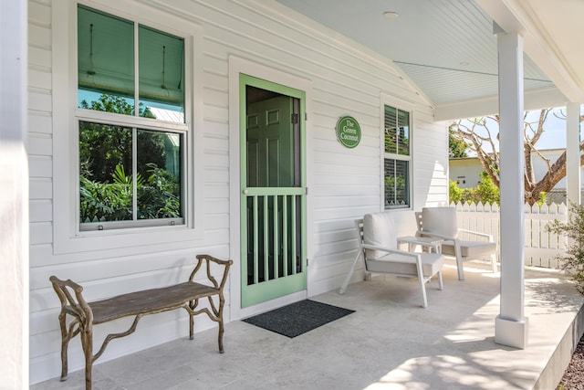 view of patio with a porch and fence