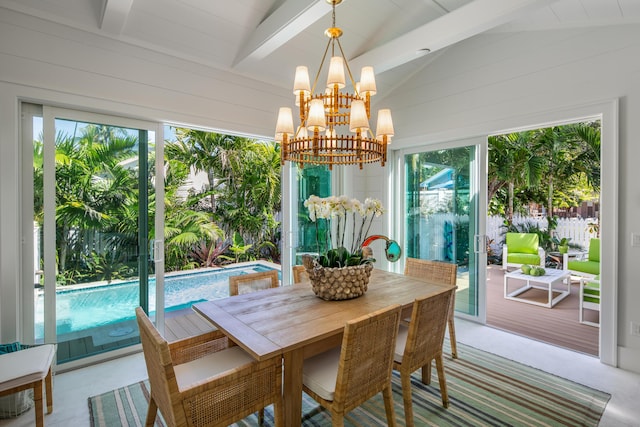 dining area featuring vaulted ceiling with beams and a chandelier