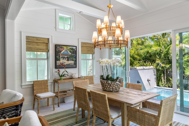 dining space with vaulted ceiling with beams, a chandelier, and wooden walls