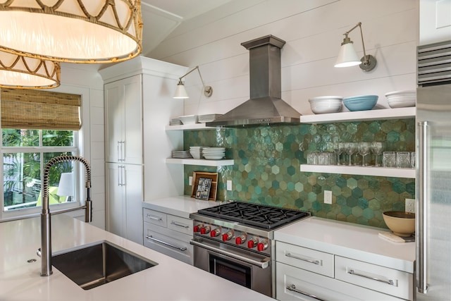 kitchen with decorative backsplash, high quality appliances, extractor fan, open shelves, and a sink