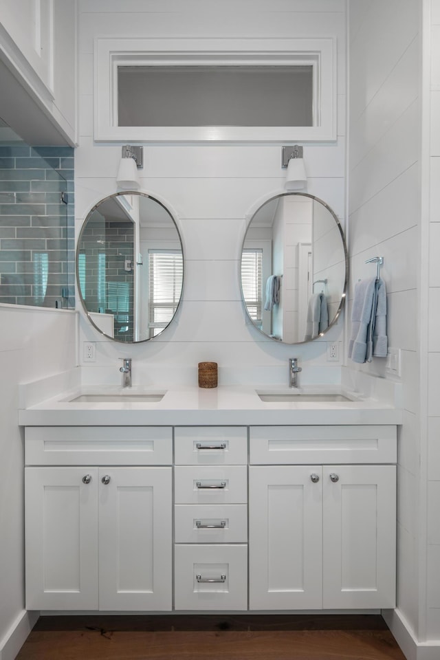 full bath featuring double vanity, tasteful backsplash, and a sink