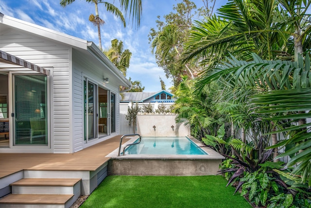 outdoor pool with a lawn and fence