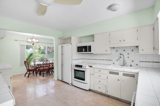 kitchen featuring white cabinetry, sink, white appliances, and tile counters