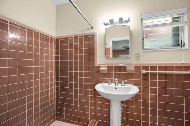 bathroom with a tile shower and tile walls