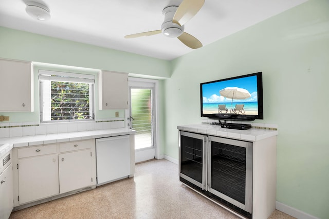 kitchen featuring ceiling fan, tile countertops, white cabinets, and refrigerator