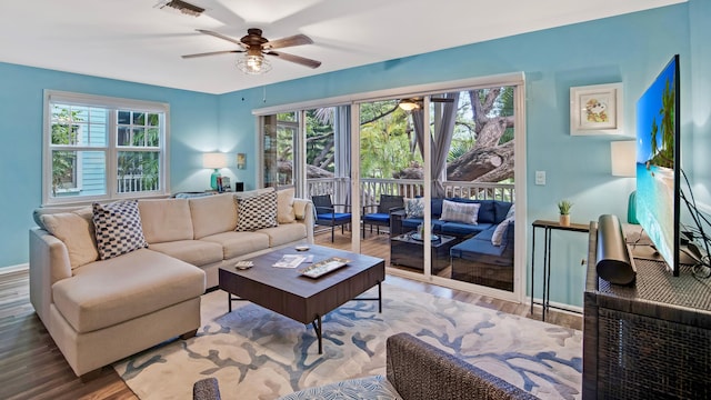 living room featuring hardwood / wood-style flooring, ceiling fan, and plenty of natural light