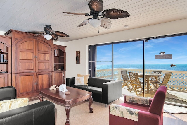 living room with ceiling fan, a water view, and wood ceiling