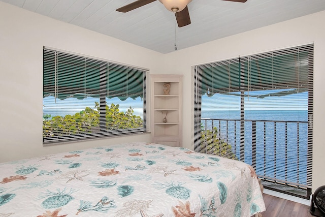 unfurnished bedroom with a water view, ceiling fan, wood-type flooring, and wood ceiling