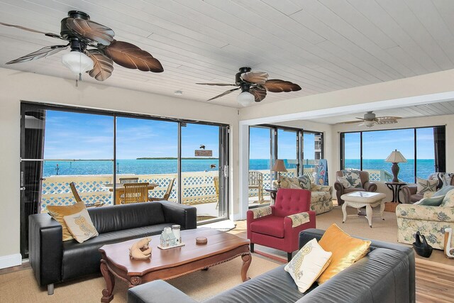 sunroom featuring a water view and ceiling fan