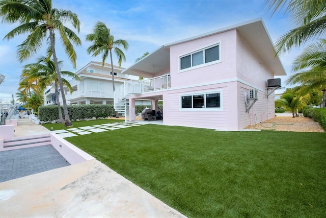 121 Lisbon Ct, Islamorada, FL 33036 - rear view of house featuring stairway, a yard, central AC, and stucco siding