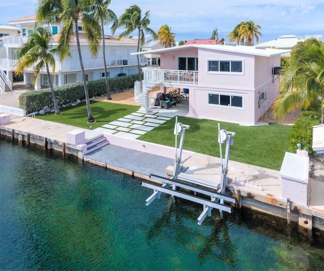 121 Lisbon Ct, Islamorada, FL 33036 - view of dock featuring a patio area, boat lift, a yard, and a water view