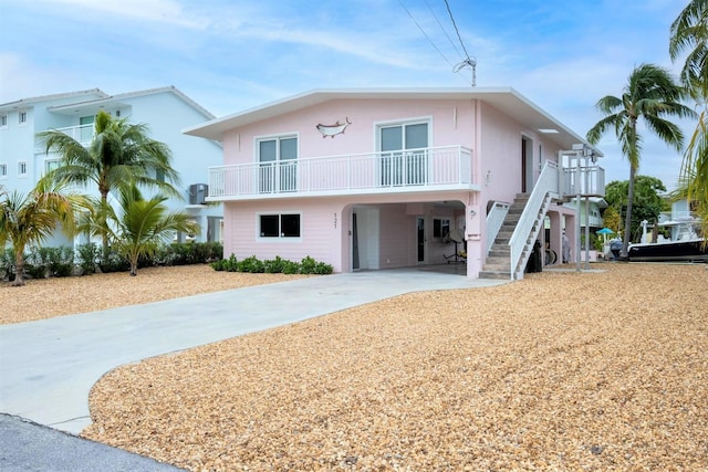 121 Lisbon Ct, Islamorada, FL 33036 - coastal inspired home featuring a carport, stairway, driveway, and stucco siding