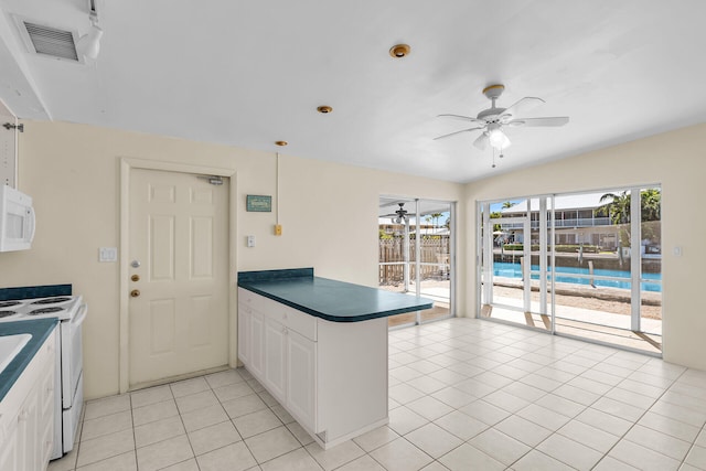 kitchen with dark countertops, visible vents, light tile patterned floors, a peninsula, and white appliances