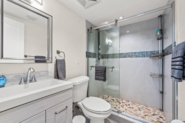 bathroom featuring vanity, toilet, and an enclosed shower